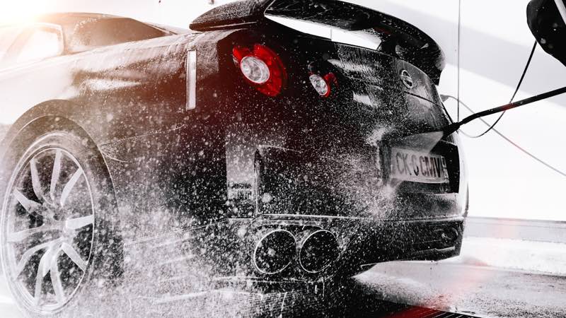 A car being rinsed clean at the detailing studio